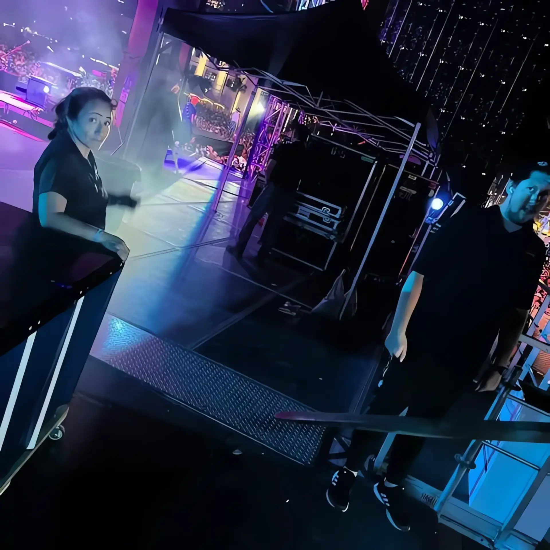 Experienced stage techs configuring sound and visual monitors backstage