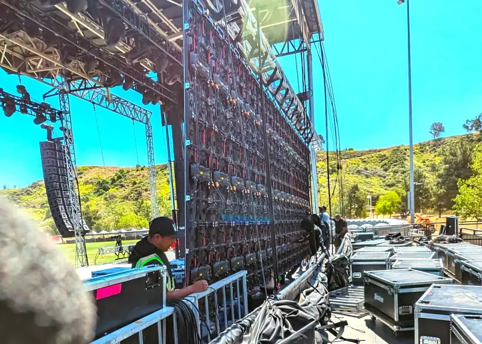 Experienced lighting technician setting up video wall